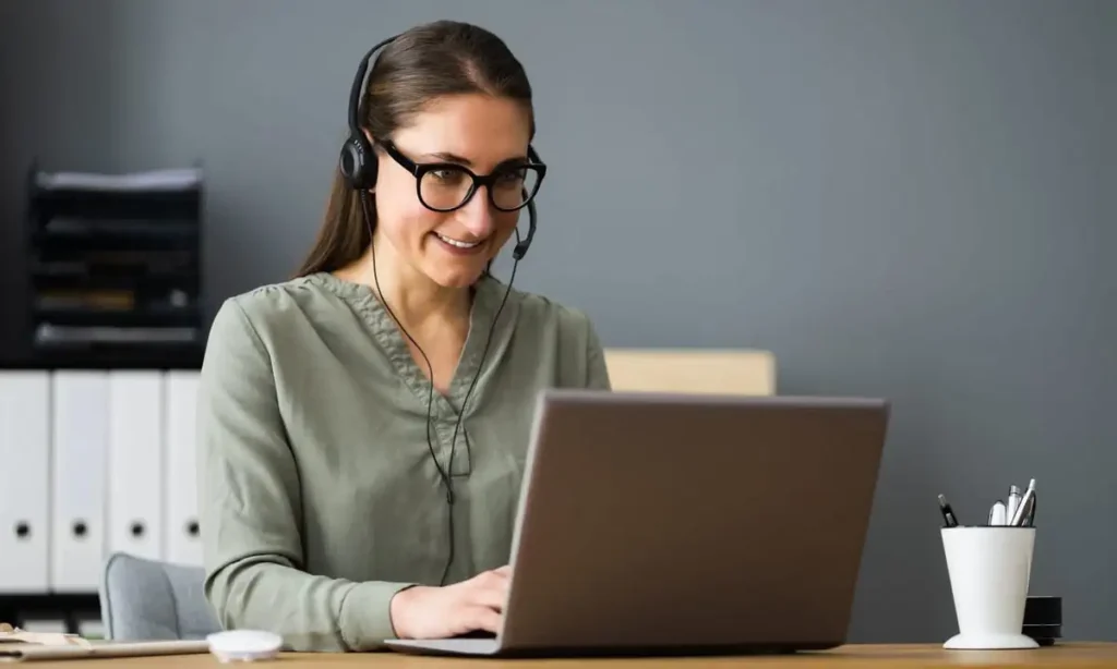 Smiling woman working on a laptop at a desk