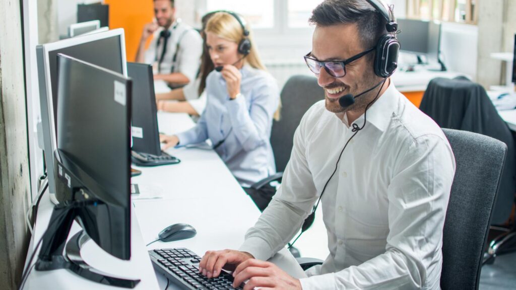 Man with a headset working at a computer in an office
