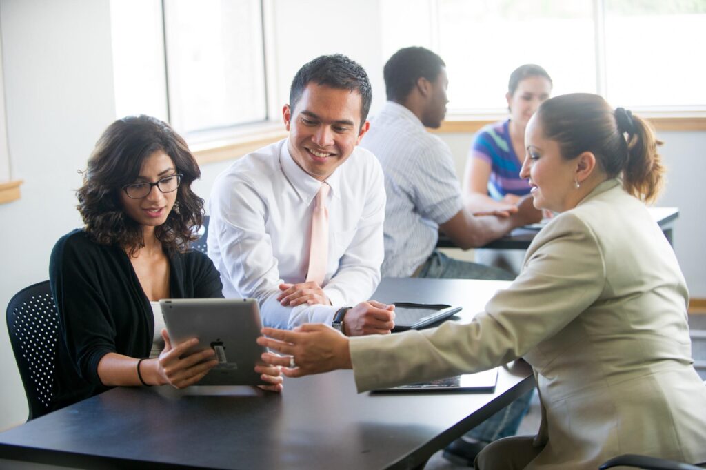Colleagues meeting around a conference table with tablets