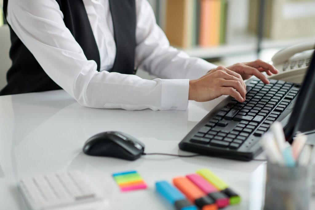 Person typing on a keyboard at a tidy desk