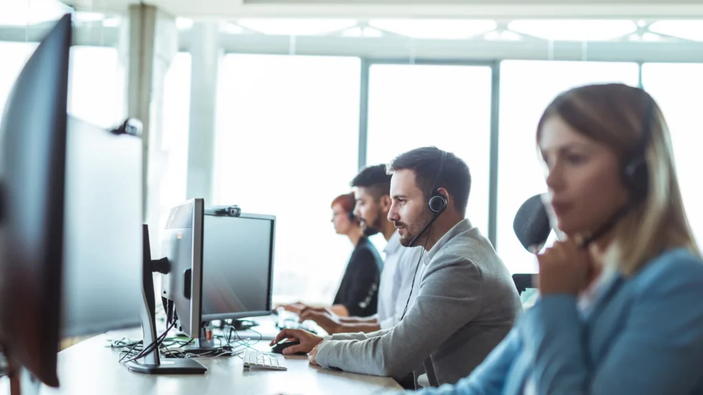 Support team with headsets working at computers